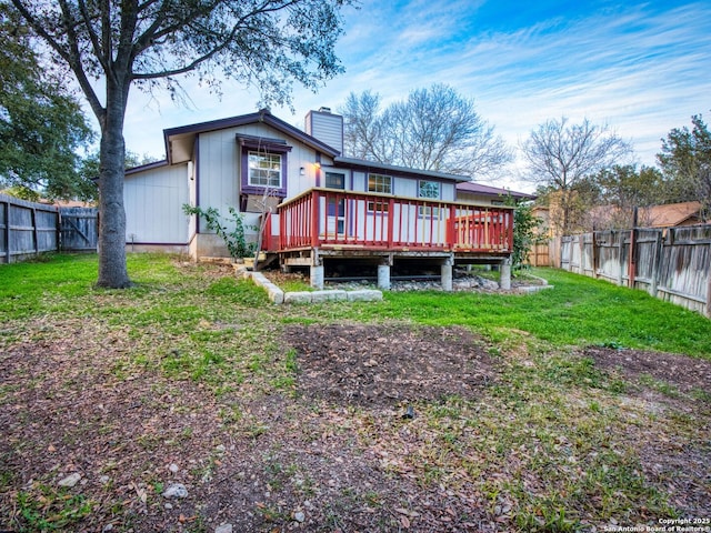 back of property featuring a lawn and a wooden deck