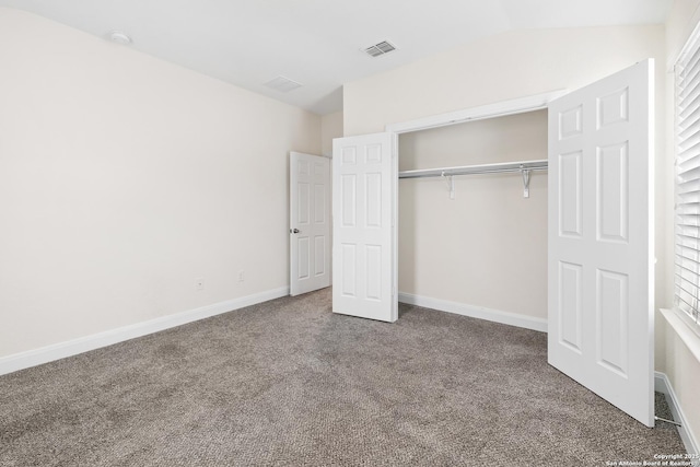 unfurnished bedroom with carpet flooring, a closet, and lofted ceiling