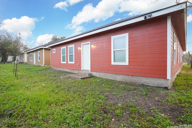 rear view of house featuring a lawn