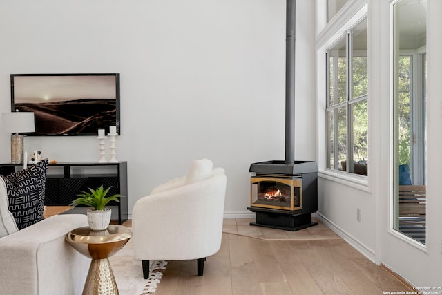 sitting room with light hardwood / wood-style floors and a wood stove