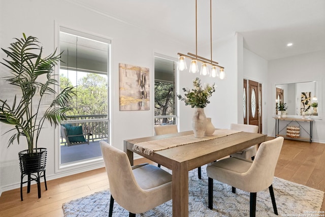 dining area with hardwood / wood-style floors and ornamental molding