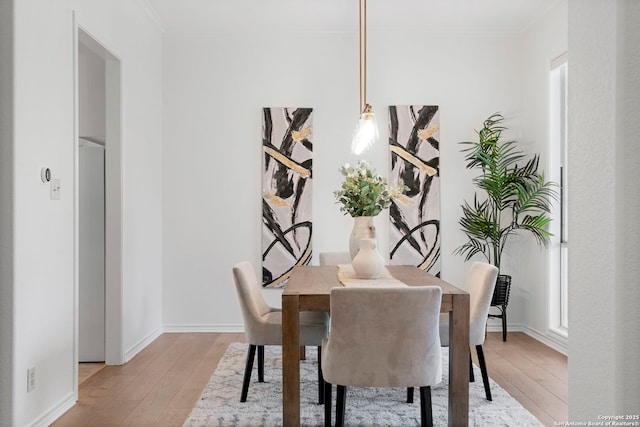 dining room with hardwood / wood-style floors and ornamental molding