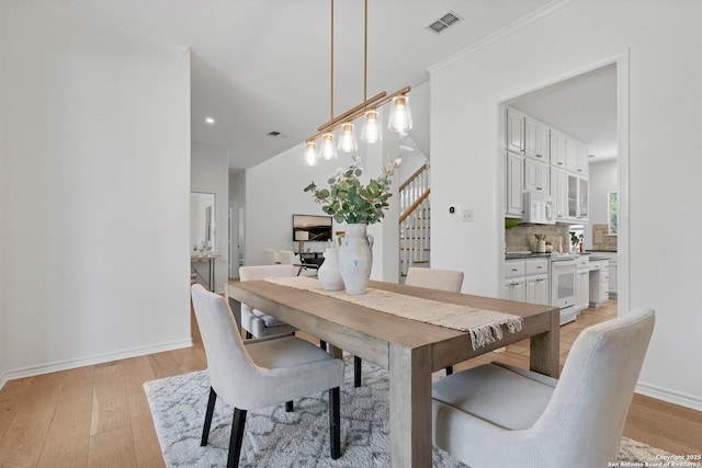 dining room with crown molding and light wood-type flooring