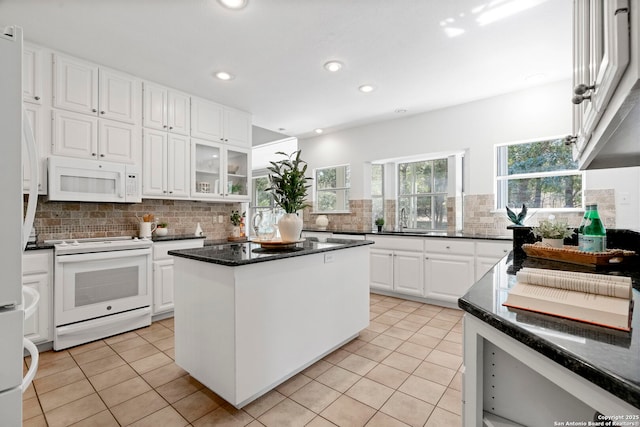 kitchen featuring a kitchen island, tasteful backsplash, light tile patterned flooring, white appliances, and white cabinets