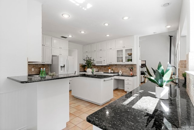 kitchen featuring white cabinets, light tile patterned floors, white appliances, and a kitchen island