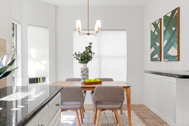 tiled dining space featuring an inviting chandelier