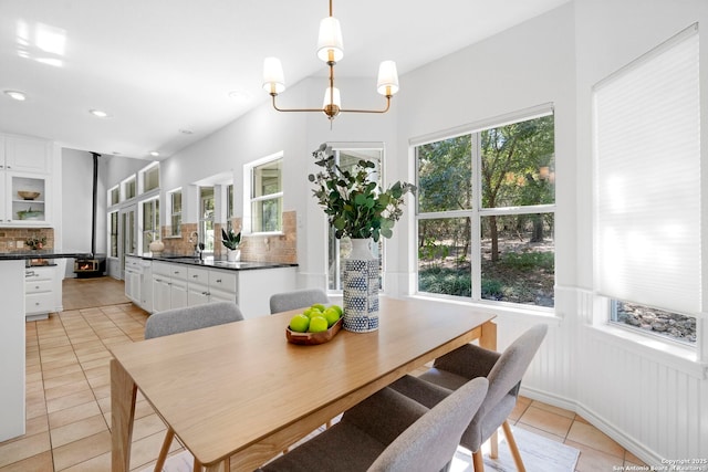 dining room with sink, light tile patterned flooring, and an inviting chandelier