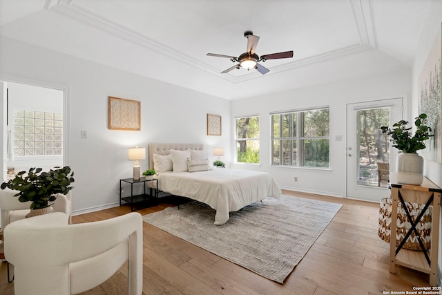 bedroom with ceiling fan, a raised ceiling, light wood-type flooring, access to outside, and ornamental molding