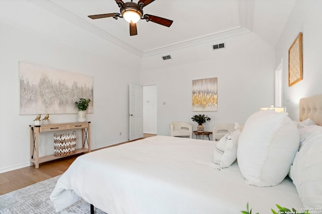 bedroom featuring a raised ceiling, ceiling fan, crown molding, and hardwood / wood-style flooring