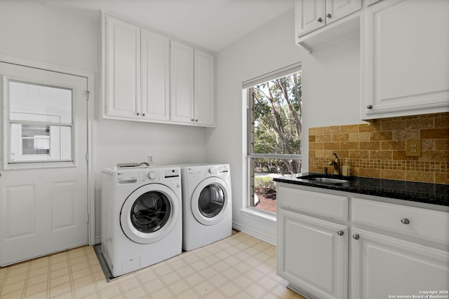 clothes washing area with cabinets, separate washer and dryer, and sink