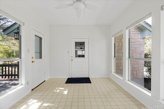 unfurnished sunroom with ceiling fan