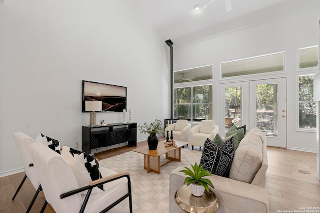 living room featuring french doors, ceiling fan, crown molding, light hardwood / wood-style floors, and lofted ceiling