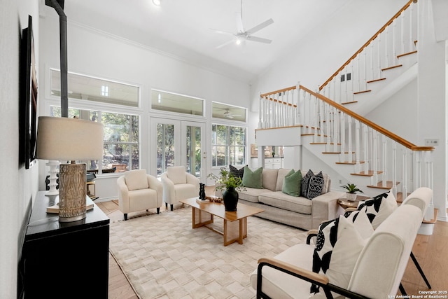 living room featuring ceiling fan, light hardwood / wood-style floors, ornamental molding, and french doors