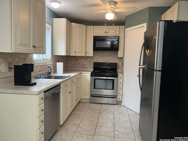 kitchen featuring sink, tasteful backsplash, a textured ceiling, light tile patterned floors, and appliances with stainless steel finishes