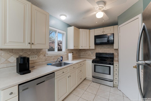 kitchen with sink, ceiling fan, light tile patterned floors, a textured ceiling, and appliances with stainless steel finishes