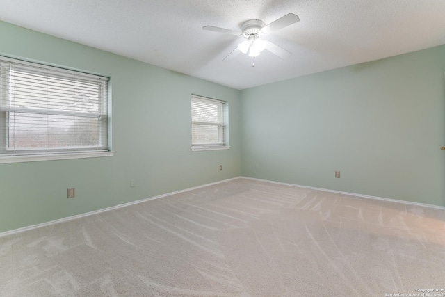 carpeted empty room with ceiling fan and a textured ceiling