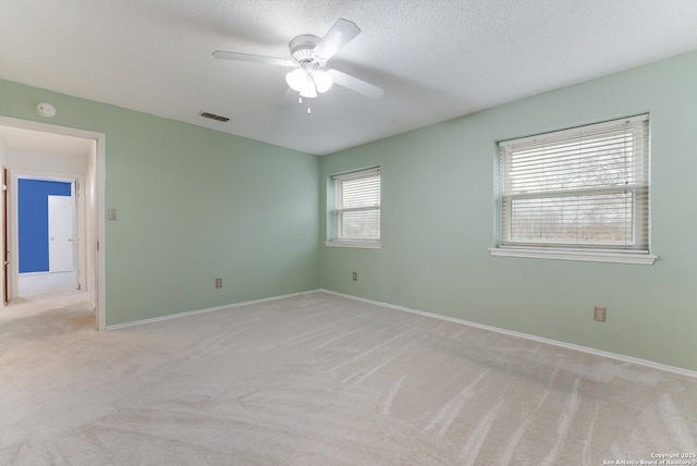 empty room with light carpet and a textured ceiling