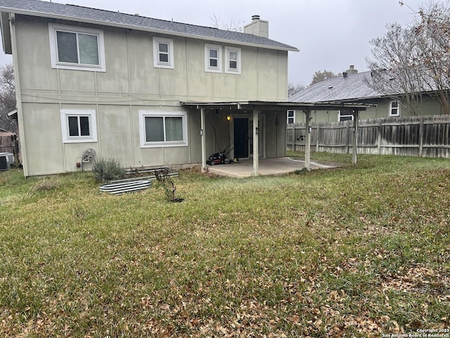 back of house with cooling unit, a patio area, and a yard