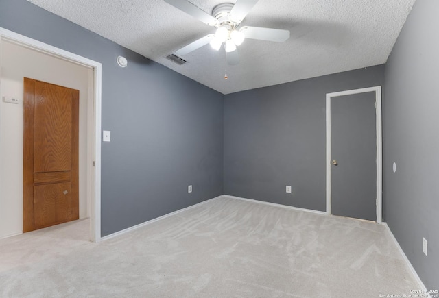 spare room with light carpet, a textured ceiling, and ceiling fan