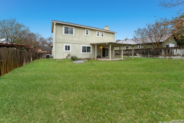 rear view of property featuring central AC unit, a patio area, and a lawn