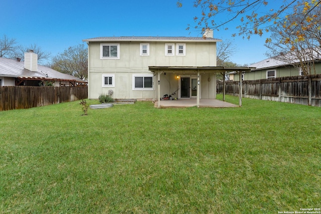 rear view of property with a yard and a patio area