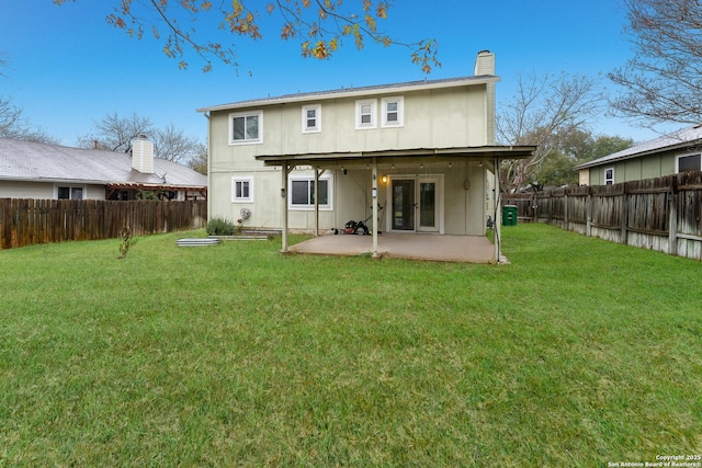 rear view of property with a yard and a patio