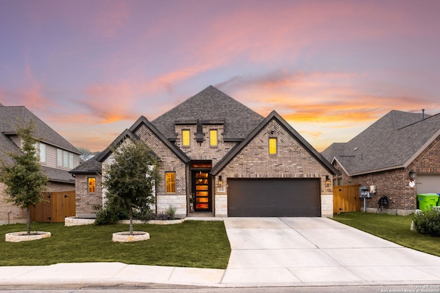 view of front of property with a garage and a lawn