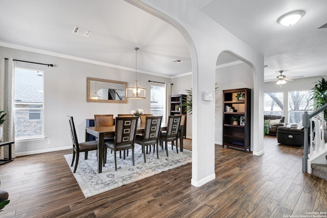 dining space with ceiling fan with notable chandelier, dark hardwood / wood-style flooring, and ornamental molding