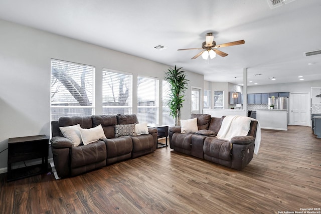 living room featuring ceiling fan and dark wood-type flooring