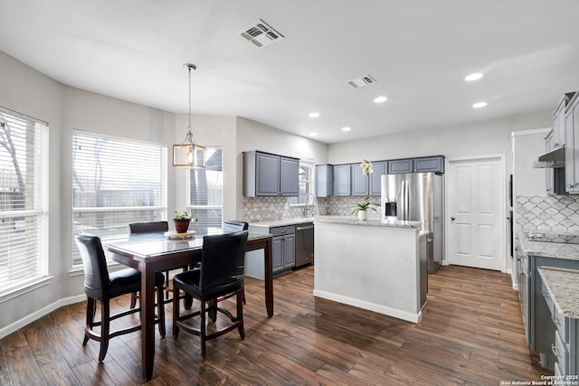 dining room featuring dark hardwood / wood-style flooring, a healthy amount of sunlight, and sink