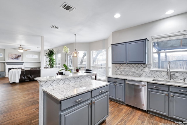 kitchen with ceiling fan, dishwasher, sink, hanging light fixtures, and a kitchen island