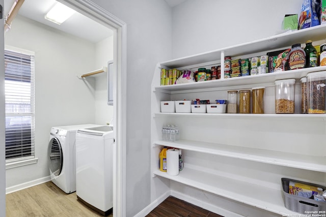 laundry room with washer and clothes dryer and wood-type flooring