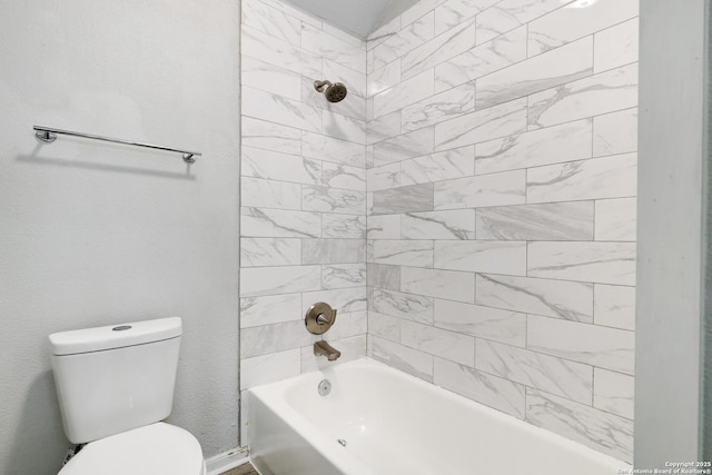 bathroom with toilet and tiled shower / bath