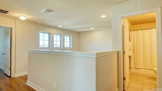 corridor featuring a textured ceiling