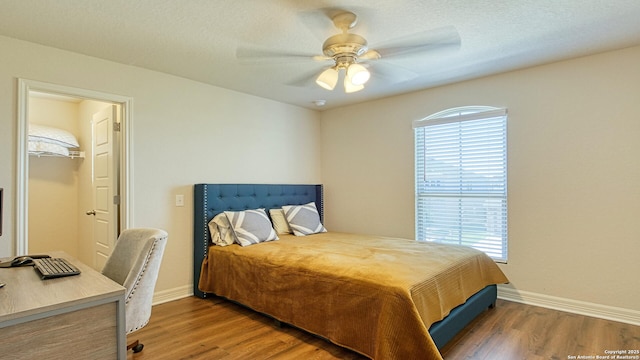 bedroom featuring ceiling fan, dark hardwood / wood-style floors, and a textured ceiling