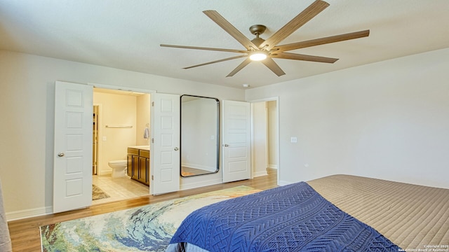 bedroom with ensuite bath, ceiling fan, and light hardwood / wood-style floors