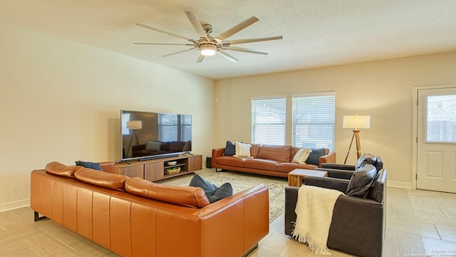 living room featuring ceiling fan and a textured ceiling