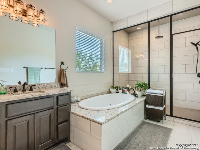 bathroom with tile patterned floors, vanity, and separate shower and tub