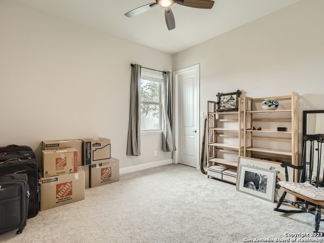 living area with ceiling fan and light carpet