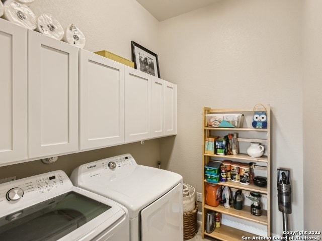 laundry room featuring cabinets and washer and clothes dryer