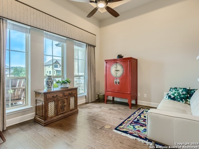 living area with light wood-type flooring and ceiling fan