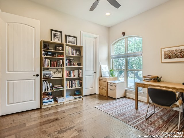 home office with ceiling fan and light hardwood / wood-style flooring