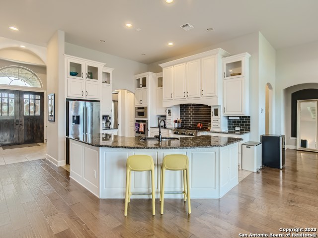 kitchen with white cabinets, a large island, sink, and stainless steel appliances