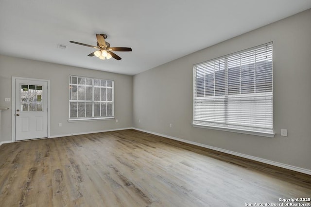 spare room with ceiling fan, plenty of natural light, and light wood-type flooring