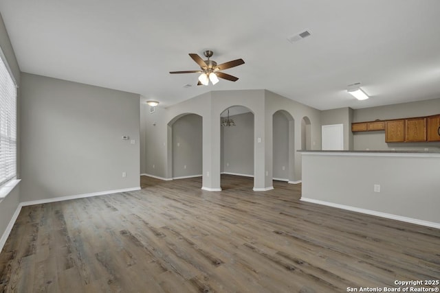 unfurnished living room featuring hardwood / wood-style floors and ceiling fan with notable chandelier