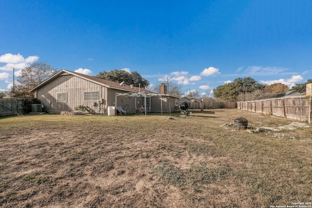 view of yard with central air condition unit and an outdoor fire pit