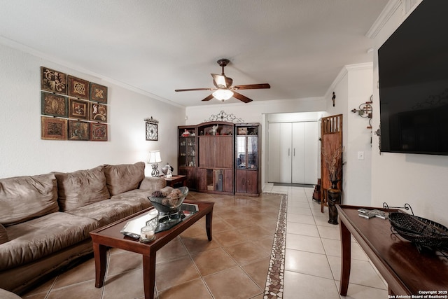 living room with ceiling fan, crown molding, and light tile patterned flooring