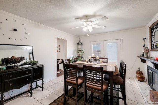 dining space featuring light tile patterned floors, a textured ceiling, and crown molding