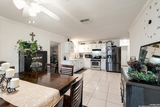 dining area featuring ceiling fan, crown molding, light tile patterned floors, and sink