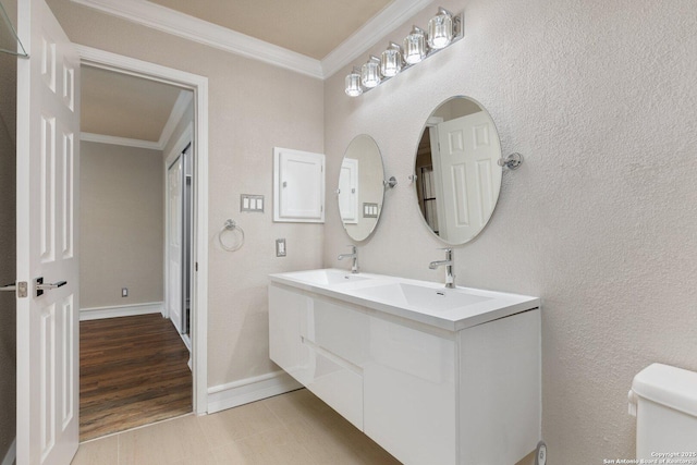 bathroom featuring toilet, hardwood / wood-style floors, crown molding, and vanity